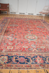 Antique Sultanabad rug shows coral-red field, floral motifs, lavender-mauve border, with wear to knot heads.