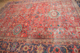 Antique Sultanabad carpet featuring coral-red field, unique lavender-purple border, and distressed pile.