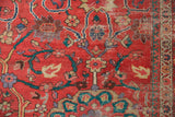 Antique Sultanabad rug detail: coral-red field, lavender and teal floral motifs, pile worn to knot heads.