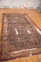 Angled view of antique Fereghan carpet, showcasing detailed Herati design, indigo field, and visible foundation.