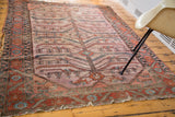 Distressed Lilihan rug section with bold serrated motifs in aged terracotta, mauve, and blue.