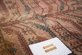 Antique Lilihan rug detail: distressed pile, exaggerated serrated patterns, blush, terracotta, blue.