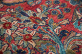 Exquisite floral bouquets on a cherry red field of a hand-knotted Sarouk rug.