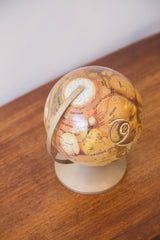Visible section of an early 1970s Mars globe in rich orange and brown.