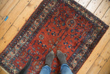 Simplistic geometric drawing in ruby red and sapphire blue on vintage Malayer rug.