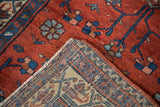 Folded vintage Persian Malayer rug showing ruby red pile and finely woven geometric reverse.