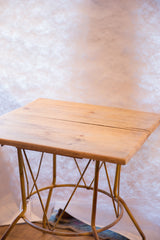 Square reclaimed wood top with intersecting yellow metal base.