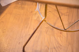 Yellow metal base of the handmade reclaimed table with a small tag.