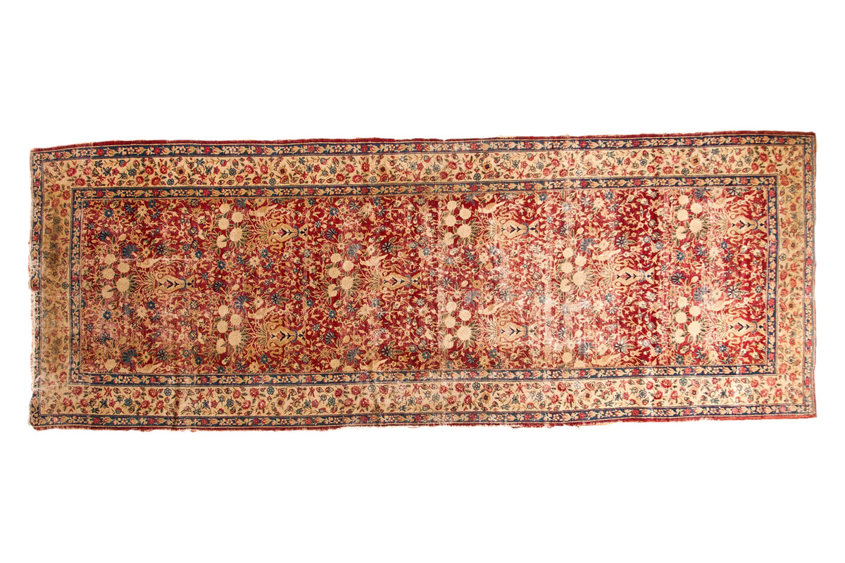Antique Kerman fragment rug; cochineal red field, bird and vase motif, antique ivory, denim blue.