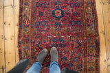 Vintage Persian Merhaban rug, raspberry painted field, floral borders, and visible white knots.