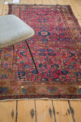 Detail of vintage Merhaban rug: raspberry painted field, saturated tones, large floral border, visible white knots.