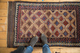 Vintage Belouch rug corner showing striped selvage, zig-zag, and reciprocating wave borders.