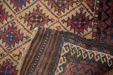 Folded vintage Belouch rug showing hand-knotted weave and distinct striped reverse.