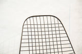 The curved top and welded wire grid construction of an Eames chair back.