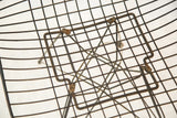Underside view of the original Eames wire chair showing the seat frame and hardware.