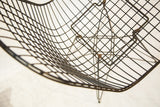 Detailed view of the sculptural wire grid forming the seat of an early Eames chair.