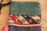 Detail of the stocking's green suede cuff and colorful, textured antique rug section.