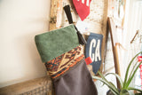 Green suede cuff with black leather hanging loop and tassel on a holiday stocking.
