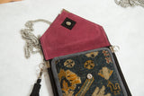 Antique Turkish rug fragment bag, burgundy suede lining, metal chain, blue and yellow pattern.