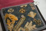 Antique Turkish rug fragment with deep blue, golden yellow bird motif, and metal snap.