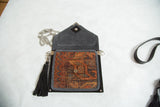 Antique Kurdish rug bag open, revealing the dark suede interior, snap, and black tassel.