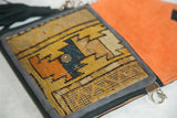 Geometric yellow and orange antique Caucasian rug fragment on the bag flap with magnetic snap.