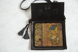 Open leather messenger bag showing the antique Caucasian rug lining and black suede interior.