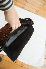 Interior view of the Kurdish rug bag showing its black suede flap and leather zipper pocket.