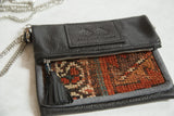 Textured antique Kurdish rug fragment with geometric pattern in rich orange, teal, and brown.