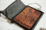 Textured antique Kurdish rug fragment with blue and terracotta design, black leather, and metal zipper.