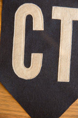 CT Felt Flag detail: hand-sewn cream letter C on textured navy felt.