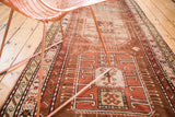 Antique Caucasian runner with geometric motifs in bronze, copper, and beige tones.