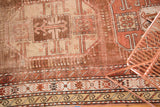 Antique Caucasian runner with geometric motifs across its bronze, copper, and ivory border and field.