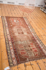 Fringe and geometric borders on an antique Caucasian runner, showing aged patina.