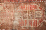 Close-up of geometric design on antique Caucasian runner, showing aged patina in copper, bronze, and ivory.
