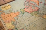 Close-up of a 1930s Cram's World map showing North America and Asia in muted colors.