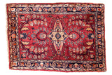 Vintage Sarouk rug mat with wine red field, floral bouquet medallion, and navy blue borders.