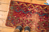 Antique Yastic rug's shabby-chic wear, raspberry red, cobalt blue, and pistachio green vines.
