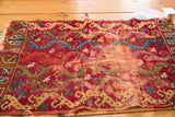 Worn central field of the antique Yastic rug, revealing copper tones and vine patterns.