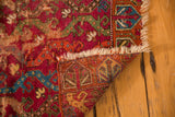 Worn raspberry red vine, tattered fringe, geometric reverse of antique Yastic rug.