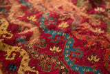 Antique Yastic rug detail: raspberry red field, cobalt blue vines, and fine worn pile revealing underlying foundation.