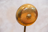 Vintage brass Major Bowes TV gong showing red lettering and time-softened patina.