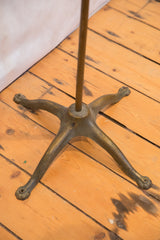 Aged brass base of the vintage 1930s TV gong, featuring four ornate claw feet.