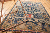 Geometric rams horn motifs in navy blue field and distressed beige side of an antique Perpedil Caucasian rug.