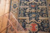 Rams horn design elements and geometric patterns on a distressed navy Perpedil Caucasian rug.
