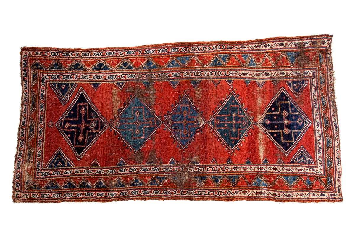 Antique Bijar rug runner, cherry brick red field with indigo blue geometric medallions, time-worn patina.