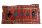 Antique Bijar rug runner, cherry brick red field with indigo blue geometric medallions, time-worn patina.