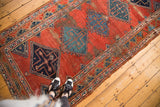 Hand knotted Persian antique Bijar runner, blue geometric medallions on worn cherry brick red field.
