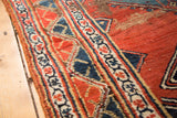 Antique Bijar rug border detail, featuring geometric red, indigo blue, and cream motifs with foundation wear.