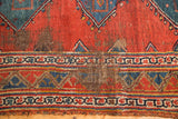 Exposed foundation and tattered geometric border of an antique Bijar runner.